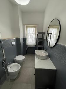a bathroom with two sinks and a toilet and a mirror at Alloggio Turistico Dea Bendata in Anzio