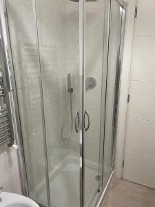 y baño con ducha y puerta de cristal. en Alloggio Turistico Dea Bendata, en Anzio