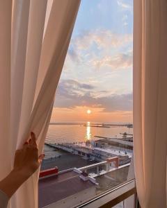 uma pessoa olhando para fora de uma janela para o oceano em Wellness СПА-Отель Грейс Горизонт em Sochi