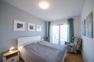 una camera da letto con un letto, una sedia e una finestra di Lipno 35 - Lipno In a Lipno nad Vltavou