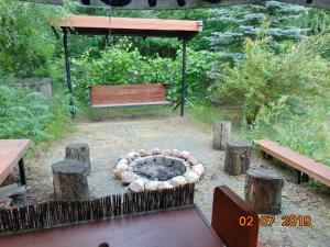 a fire pit in a garden with a bench at Dom nad Narwią - cisza spokój rzeka jezioro in Rogóźno