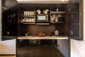 a kitchen with black walls and a counter with a microwave at Centrale Venice Apartments in Venice