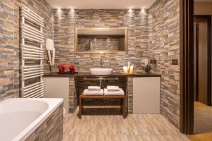 Centrale Venice Apartments في البندقية: حمام مع مغسلة وحوض استحمام +41 صورة