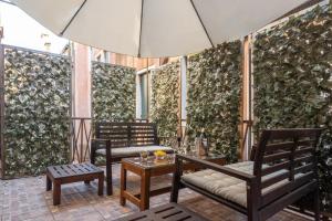 Centrale Venice Apartments في البندقية: فناء فيه كراسي وطاولة ومظلة