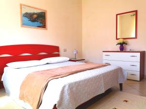 Schlafzimmer mit einem großen Bett mit einem roten Kopfteil in der Unterkunft Piccolo B in Bosa