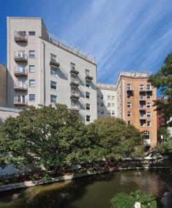 a river in front of two tall buildings at Club Wyndham Riverside Suites in San Antonio