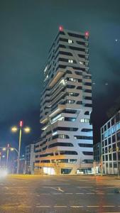 a tall building in a city at night at Sky Aparthotel in Stuttgart