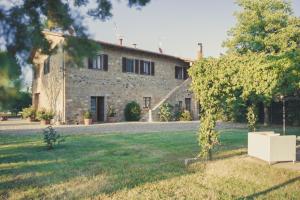 a stone house with a tree in front of it at Podere Osteria in Pienza