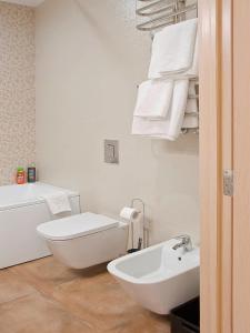 La salle de bains blanche est pourvue de toilettes et d'un lavabo. dans l'établissement Respect, à Lviv