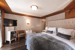 Habitación de hotel con cama grande y escritorio. en Boutique Hotel Albana Real - Restaurants & Spa en Zermatt