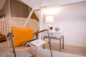 a chair with a yellow pillow sitting next to a table at Red House Loft East Green Air Manage Suffolk in Saxmundham