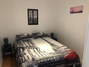 a bedroom with a bed with a black and white comforter at HYPER CENTRE - WIFI FIBRE GRATUIT - JERGWELOH - Le Parisien in Caen