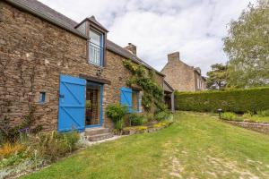 una casa de ladrillo con puertas azules y un patio en La Maitrie, en Plouër-sur-Rance