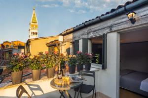 Centrale Venice Apartments في البندقية: شرفة مع نباتات الفخار على مبنى مع برج الساعة