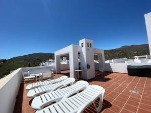 a group of white lounge chairs on a roof at Casa Bella Vista in Mojácar