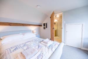 a bedroom with a large bed with towels on it at Red House Loft East Green Air Manage Suffolk in Saxmundham