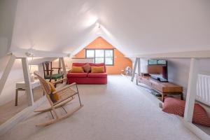 a living room with a red couch and a table at Red House Loft East Green Air Manage Suffolk in Saxmundham