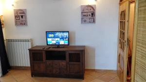 une télévision installée au-dessus d'un meuble en bois dans une pièce dans l'établissement Appartamenti Magnolia, à Positano
