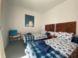 ein Hotelzimmer mit 2 Betten und einem Stuhl in der Unterkunft Casa Bella Vista in Mojácar