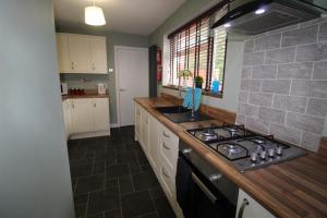 a kitchen with a stove and a counter top at Holland House in Unstone