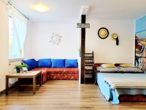 ウストカにあるApartamenty Blisko Morzaのリビングルーム(赤いソファ、青い枕付)