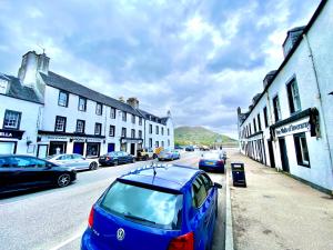 a blue car parked on the side of a street at Cosy, Modern 2 Bedroom Apartment in the Centre of Inveraray in Inveraray