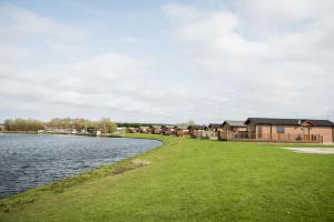 eine Reihe von Lodges neben einem Wasserkörper in der Unterkunft Ream Hills Holiday Park in Blackpool