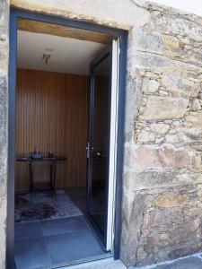 una puerta de cristal que da a un edificio de piedra con una mesa en Quinta das Fontainhas en Mesão Frio