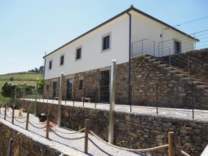 un bâtiment au-dessus d'un mur en pierre dans l'établissement Quinta das Fontainhas, à Mesão Frio