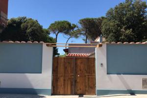 馬里納·迪·比薩的住宿－Viareggina con giardino，白色的房子,有木门和树木