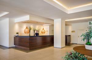 a woman standing at the reception desk of a hotel lobby at PortoBay Falesia in Albufeira