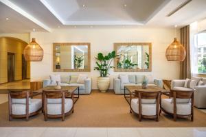 a living room with a couch and tables and chairs at PortoBay Falesia in Albufeira