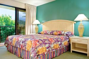 a bedroom with a bed with a colorful bedspread at Kauai Beach Villas in Lihue