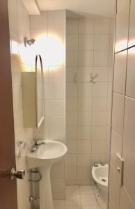 Baño blanco con lavabo y aseo en Departamento Céntrico Bariloche con patio en San Carlos de Bariloche