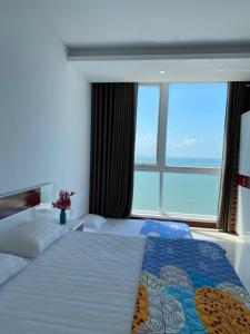a bedroom with a bed with a large window at Sơn Thịnh - Oasky Apartment in Vung Tau
