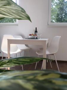 biała jadalnia z białym stołem i krzesłami w obiekcie Haus Geiger w mieście Hörbranz