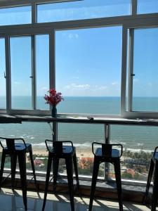 Son Thinh Apartment في فنغ تاو: طاولة وكراسي في غرفة مطلة على المحيط