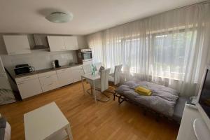 a living room with a couch and a table and a kitchen at Tübingen - auf dem Österberg - free parking in Tübingen