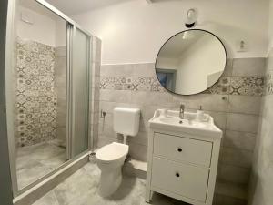 エゲルにあるPacsirta Apartman Grandのバスルーム(トイレ、洗面台、鏡付)