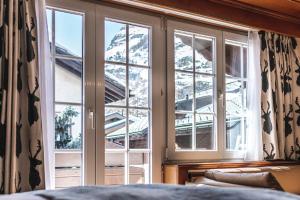 a window in a bedroom with a view of a snow covered mountain at Albana Real Boutique Hotel - Restaurants & Spa in Zermatt