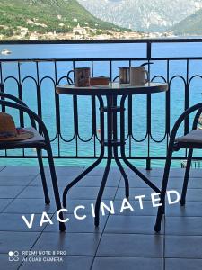 een tafel op een balkon met uitzicht op het water bij Apartment The Sea Coast in Kotor