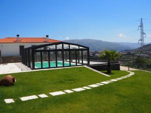a house with a swimming pool in the grass at Quinta das Fontainhas in Mesão Frio