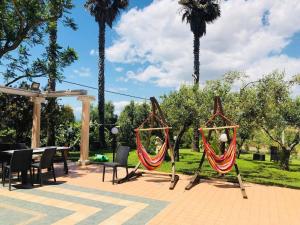 a couple of hammocks in a park with palm trees at Hotel Ristorante L'Orizzonte in Le Castella