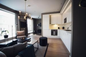 a kitchen and living room with a couch and a table at Sky Hotel Apartments, Hospitalstorget in Linköping