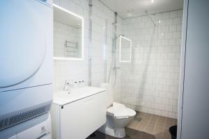 a white bathroom with a toilet and a sink at Sky Hotel Apartments, Hospitalstorget in Linköping