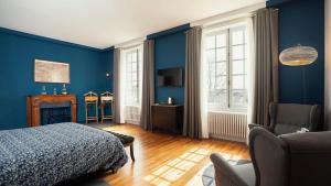- une chambre bleue avec un lit et une chaise dans l'établissement Les Chambres du Champagne Collery, à Ay