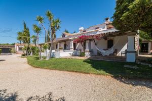 una casa con flores rosas en la parte delantera en Casa Belaventura, en Boliqueime