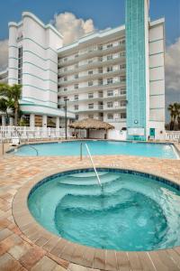 a large swimming pool in front of a hotel at Discovery Beach Resort, a VRI resort in Cocoa Beach