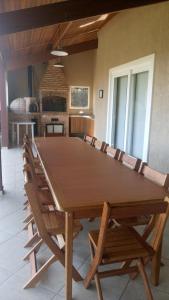una gran mesa de madera en una habitación con sillas en Linda Casa de Campo - Próximo à SP - Wi-Fi grátis, en Bom Jesus dos Perdões