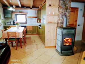 una cucina e una sala da pranzo con stufa a legna di Casa Rainolter a Livigno